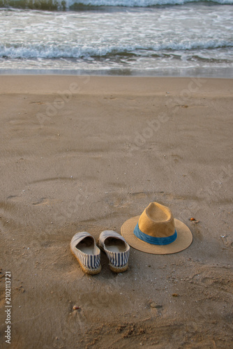 Vertical panama hat and espadrilles beside calm sea