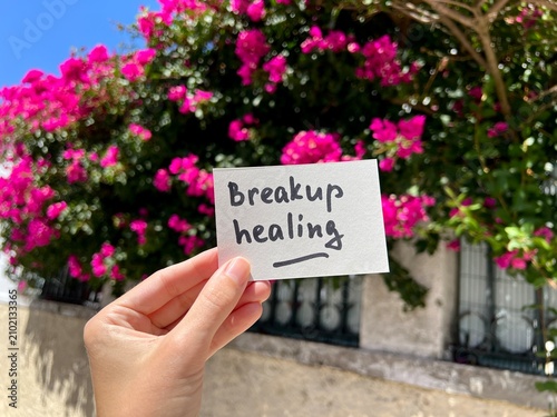 Breakup Healing - text in hand on pink flowers background, relationship and psychology concept