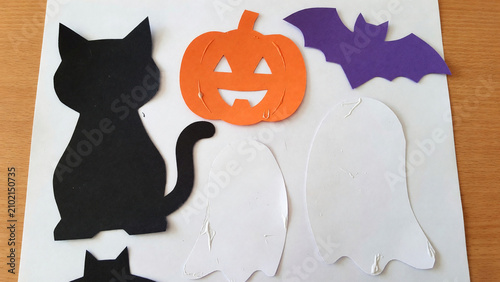 Cutout shapes of black cat, pumpkin, bat, and ghosts for Halloween  