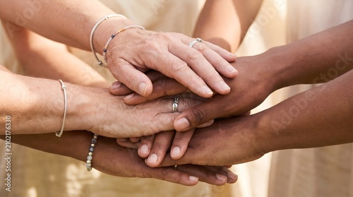 Diverse group of people joining hands together in a gesture of unity, solidarity, and cooperation