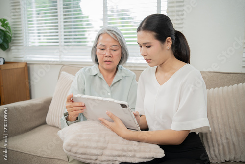 Foto An Asian caregiver gently holds an elderly woman's hand, providing attentive and