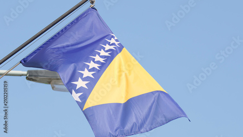 Foto National Flag of Bosnia and Herzegovina Waving Against Clear Blue Sky