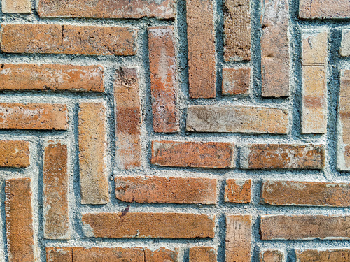 Fotografía Decorative red brick wall arranged in a varied geometric pattern, photographed close up to reveal masonry texture, mortar, and design