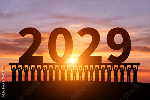Foto In the morning sun, numerous silhouettes of children are holding up the year2029