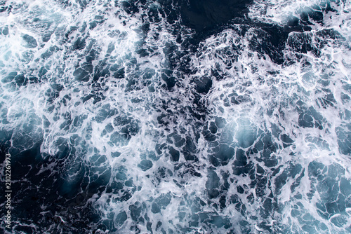 Blue ocean surface with sea foam viewed from above