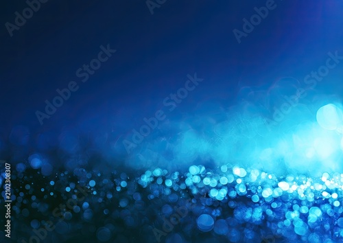 Soft blue and aqua bokeh lights shimmer and glow against a dark background