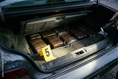 Contraband packages discovered in car trunk at crime scene