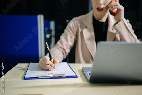 Confident business expert attractive smiling young woman holding digital tablet  on desk in creative office.