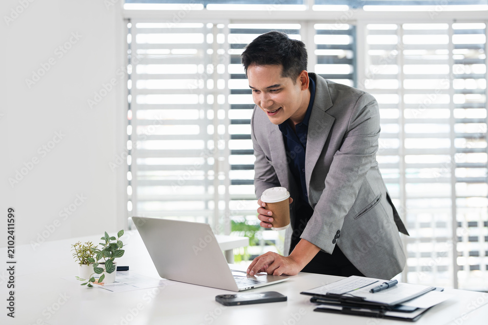 Fototapeta premium Businessman using laptop computer in office. Happy middle aged man, entrepreneur, small business owner working online.