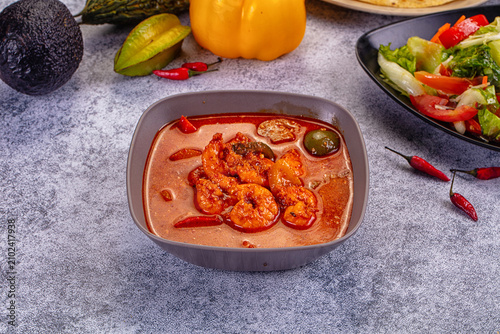 Fotografía Spicy shrimp red curry in grey bowl with chili peppers and fresh vegetables