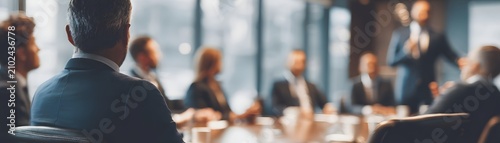 A professional meeting in a modern conference room. Attendees engage attentively as a speaker presents insights. A collaborative atmosphere fosters innovative ideas and solutions.