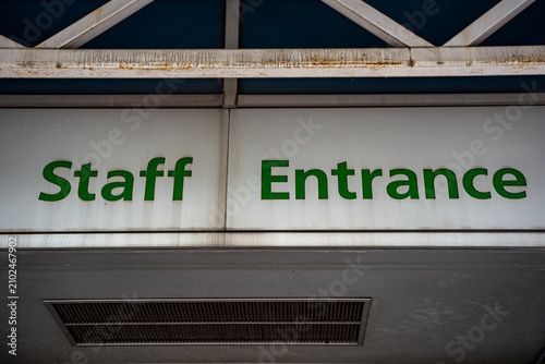 Photography Staff entrance sign on stadium exterior wall.