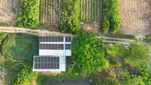 Quadro su tela Rooftop solar panels powering a sustainable rural farm surrounded by ponds, trees, organic agriculture, and renewable energy infrastructure supporting self sufficient living and clean electricity