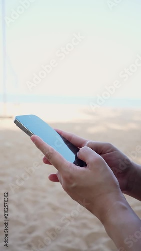 Woman using smartphone on tropical beach, mobile communication and travel lifestyle.