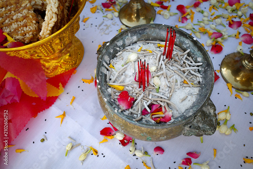 Incense sticks in ancient bronze incense burner with flower petals during Thai blessing ceremony
