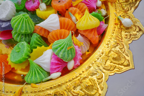 Colorful A-Lua (traditional Thai flour candy) arranged on a golden tray. These bite-sized sweets feature a crisp sugar shell with a soft, chewy center and a sweet, fragrant flavor