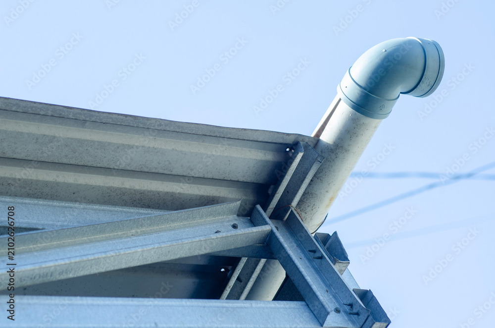 Naklejka premium Modern lightweight steel roof construction with PVC rain gutter installed under clear blue sky.