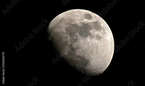 A captivating half moon, with its luminous surface, partially obscured by the darkness of space, showcasing lunar craters.