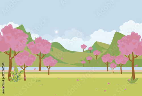 Beautiful spring landscape featuring blooming pink flowering trees on a lush green meadow