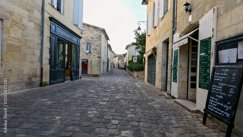Fototapeta premium Quiet Cobblestone Street with Historic Architecture in Castillon-la-Bataille France