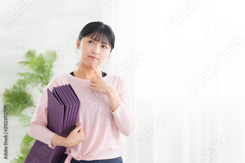 考えるヨガウェアの若い女性