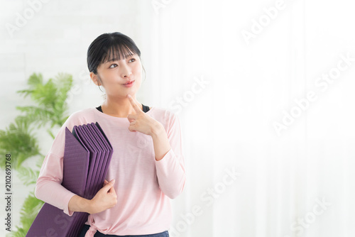 考えるヨガウェアの若い女性