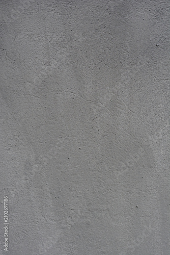 Full frame close up view of a weathered grey plaster concrete wall texture with fine grain and subtle shadows