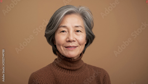 モカブラウンのタートルネックを着て穏やかに微笑む日本人シニア女性