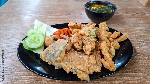 Gurame Saos Telur Asin. Crispy fried gourami fish covered with salted egg sauce. Indonesian food