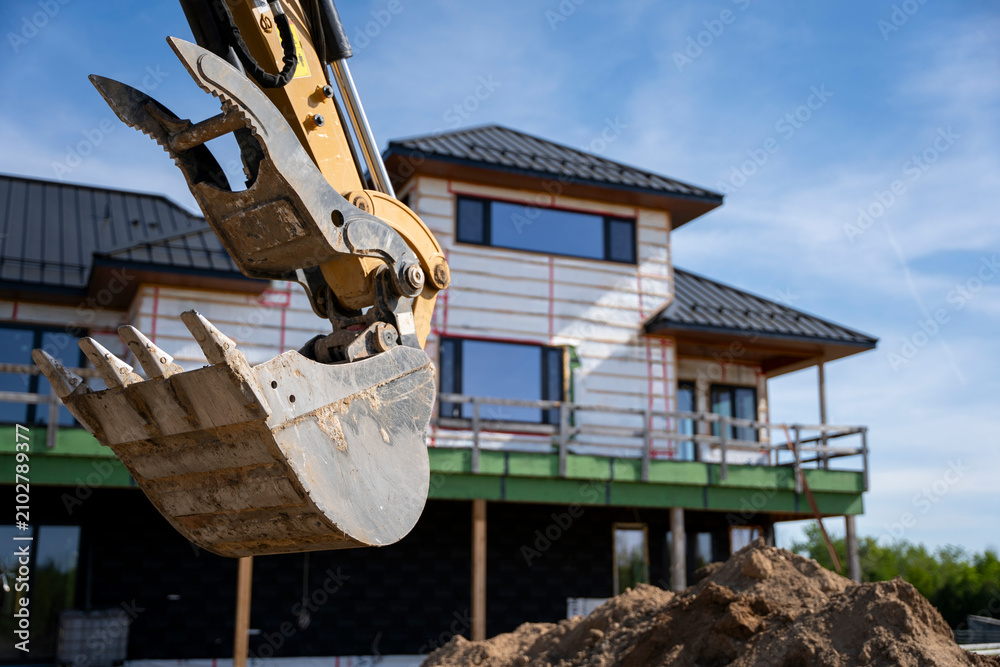 Obraz premium Excavator Bucket at Modern House Construction Site