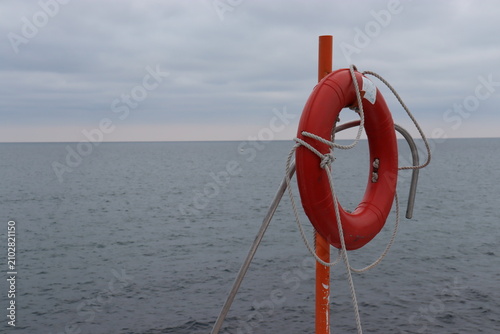 Fotografie Lifebuoy on a Pier Overlooking the Ocean