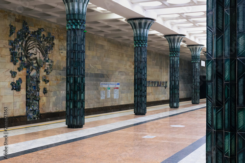 Ornate Gafur Gulom metro station interior with green ceramic columns and sculptural wall relief in Tashkent, Uzbekistan. Empty platform showcases Soviet-era decorative architecture ideal for travel.