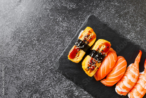 Cuadro en lienzo Delicious sushi assortment on a black stone plate setting the mood for an enjoya