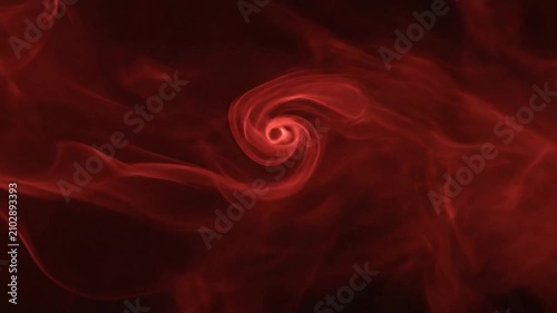 Abstract red smoke swirls against a dark black background