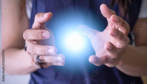 Person holding blue glowing energy sphere between hands.