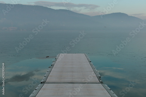 Wooden Pier Extending Into Calm Mountain Lake
