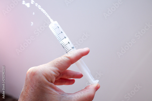 Obraz na płótnie Syringe Spraying Liquid – Medical Precision Concept