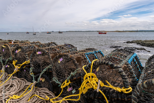 Crab pots, lobster pots, fish traps and commercial fishing gear line the quay on Holy Island, highlighting the island’s active fishing industry.