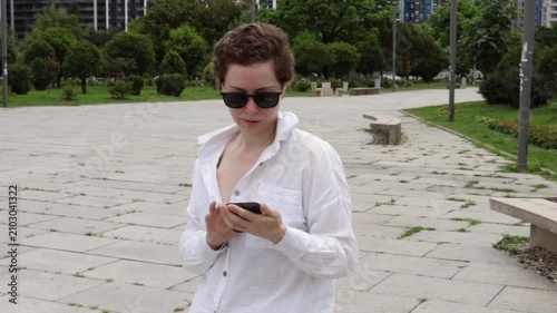 middle aged woman checks a mobile health app in a public park, representing telehealth, treatment follow up and technology supported cancer survivorship