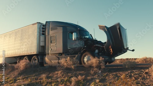 Semi truck breakdown with an open hood on a desert roadside