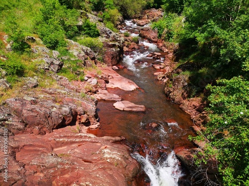 View of the Toplodolska River on Stara Planina, Serbia. The canyon of the Temstica near village Topli Do. The canyon is famous for its vibrant red rock riverbeds and beautiful small waterfalls