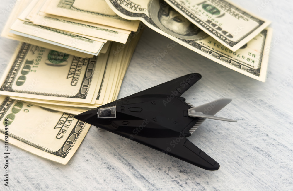 Obraz premium military miniature toy airplane on dollars background