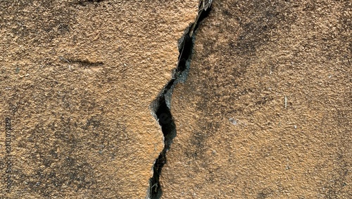 Photos Vertical structural crack running through a textured concrete block wall, indica
