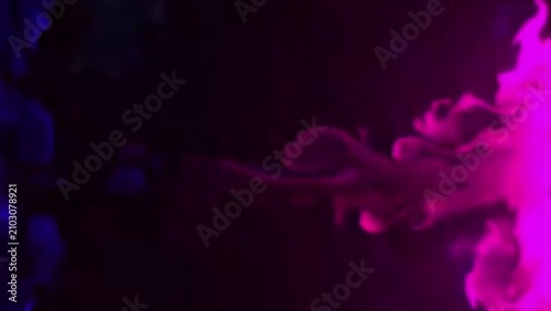 Vibrant plumes of blue and magenta smoke drift and intertwine in an enigmatic dance against a dark backdrop, an abstract concept of ethereal movement 4K
