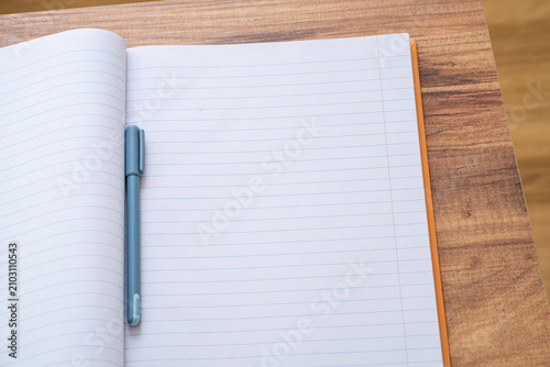 Foto Open blank notebook with pen on wooden desk