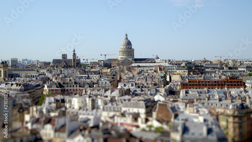 Photography Panoramic view over Paris rooftops with the Panthéon rising above the city skyline on a clear sunny day