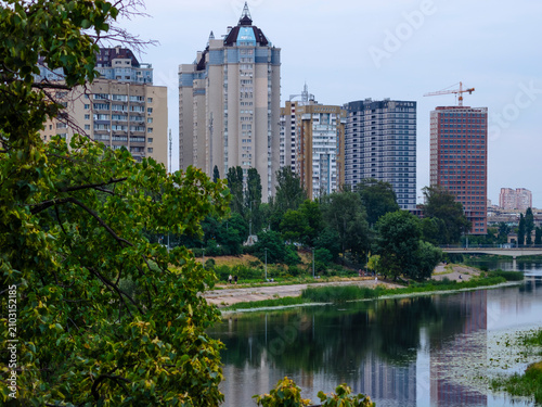 Bild auf Leinwand Dnipro river channel reflecting dense urban skyline with modern buildings and co