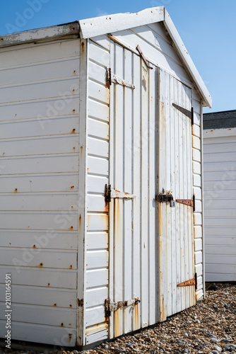 Fotografía Weathered white beach hut with rusted door hinges