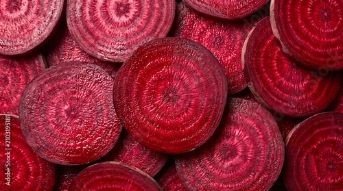 Vibrant cross sections of freshly sliced red beetroot displaying organic concentric rings in a high contrast macro food photography composition