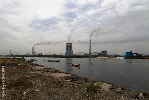 Konstfotografi A coastal power plant stands beside the sea and backwaters during the early morning, reflecting the balance between energy production and environmental stewardship